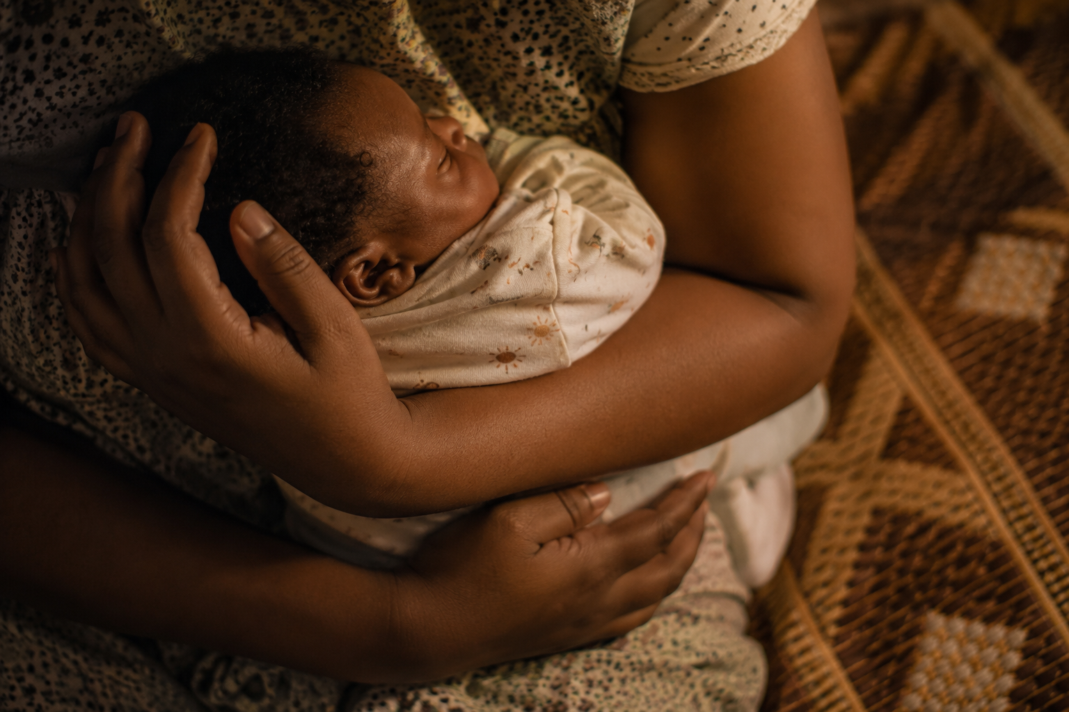 Hands holding sleeping newborn